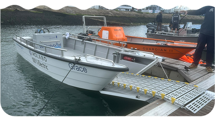 The Boat Card Image: BoatHub's accessible electric boat moored beside a marina.